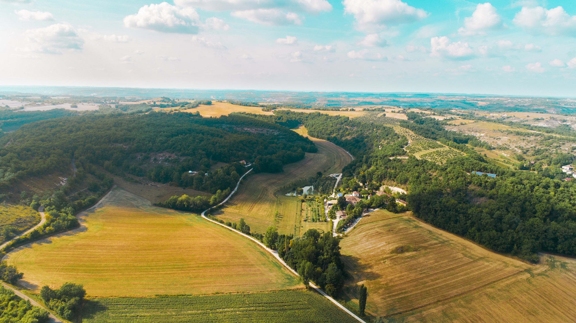 Vue aérienne du Domaine de Saint-Géry, bâtisses en pierre, jardins et bois du Quercy blanc dans le Lot