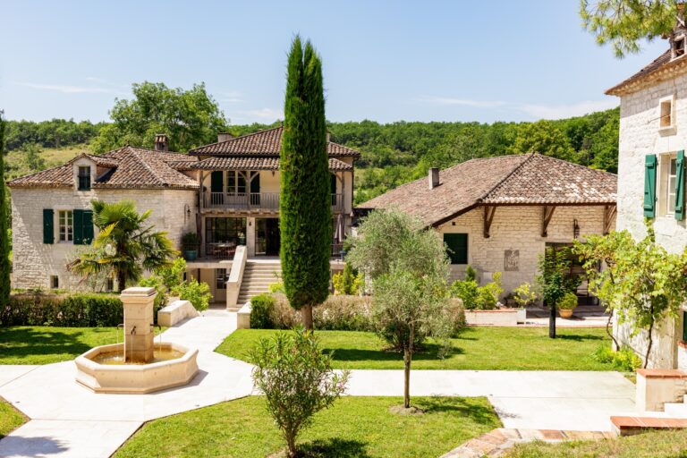 Jardin et fontaine en pierre devant les bâtiments du Domaine de Saint-Géry